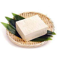 Block of fresh tofu on bamboo leaves